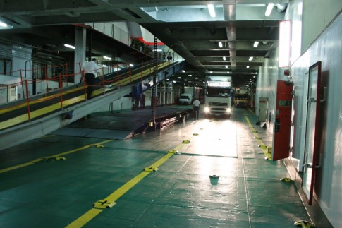 The ship's compact main vehicle deck with the ramp leading to the upper deck visible. 