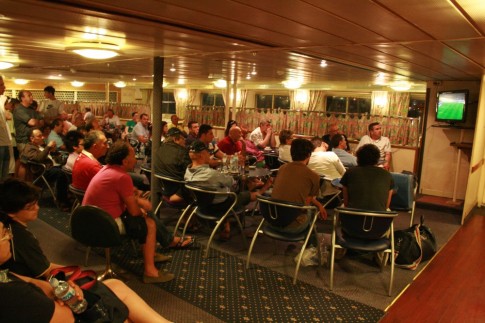 Passengers crowd into the lounge area to watch football.