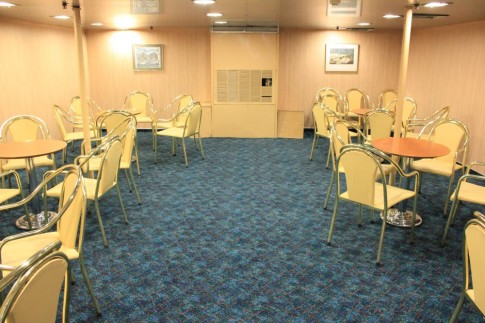 Forward of the tea bar on the ship's centreline was once the Duty Free shop is now an additional, windowless, area of seating. This has inherited some of the generic chairs (from Primo in London) which were installed in the cafeteria upstairs during the late 1980s.