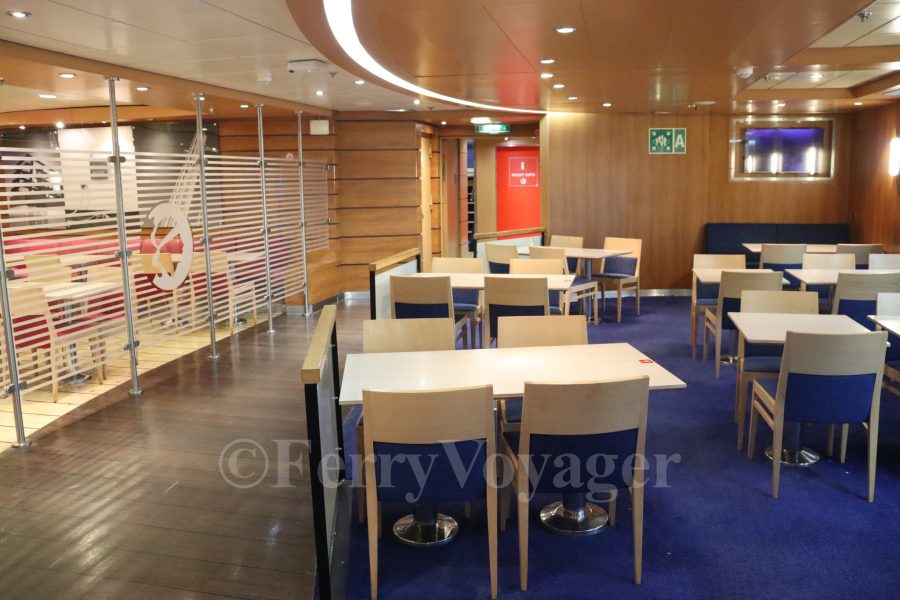 Originally, amidships on Deck 7 housed the cafeteria, à la carte restaurant and a small adjoining cocktail bar. SeaFrance stripped the area out to become an expanded self-service cafeteria, but today it is once again divided into a smaller cafeteria (to starboard) and a brasserie restaurant (centrally and to port, seen behind the glass bulkhead here)