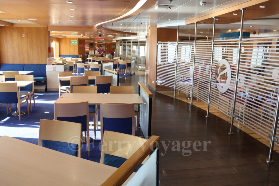 Originally, amidships on Deck 7 housed the cafeteria, à la carte restaurant and a small adjoining cocktail bar. SeaFrance stripped the area out to become an expanded self-service cafeteria, but today it is once again divided into a smaller cafeteria (to starboard) and a brasserie restaurant (centrally and to port, seen behind the glass bulkhead here)